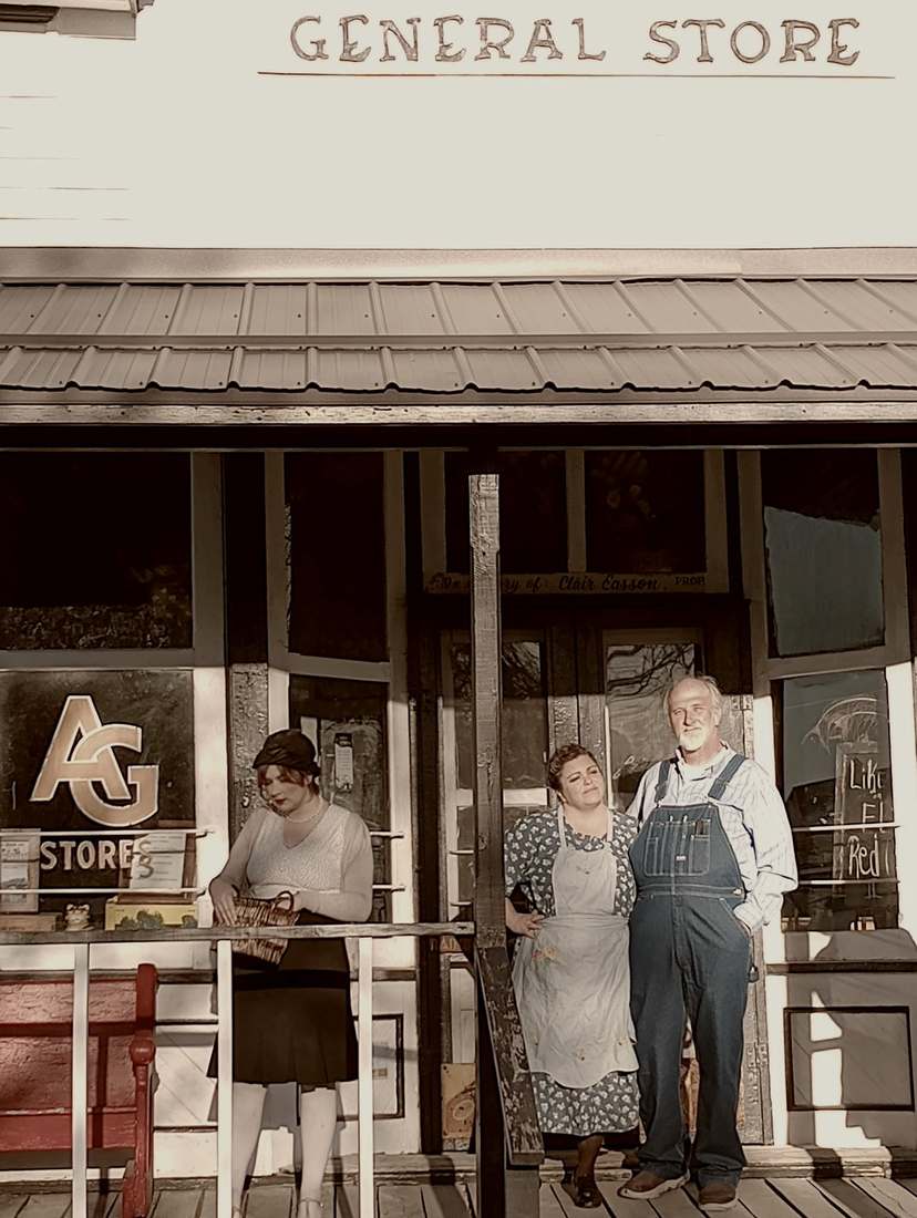 Three cast members on the porch of an old general store (sepia)