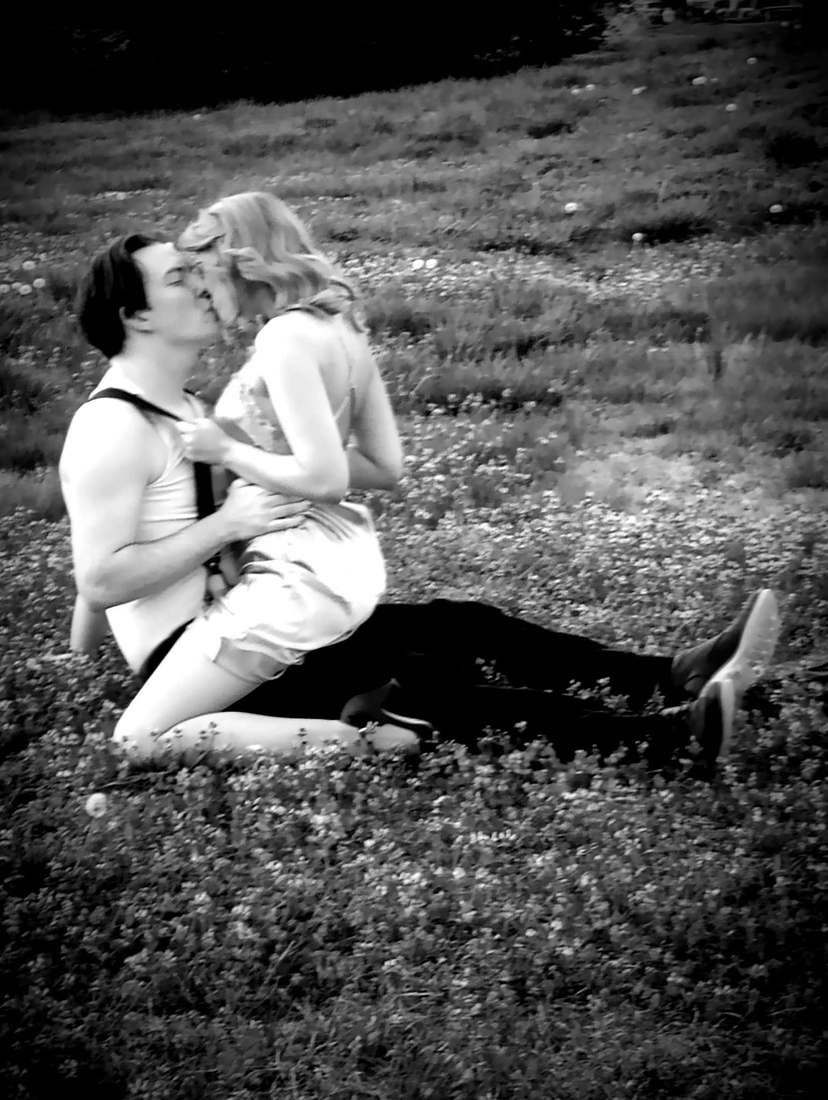 Bonnie and Clyde kissing in a field of clover (black and white)