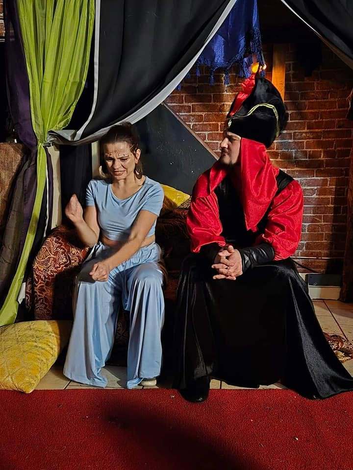 The princess and the Vizier share a laugh on the palace couch in Twisted