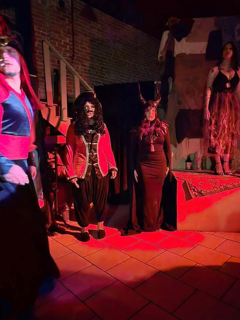 Visiting villains — a captain in a red coat and a horned queen — bathed in red light in Twisted