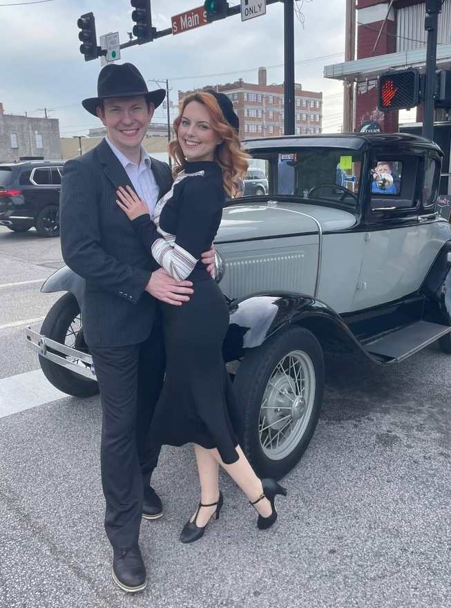 Bonnie and Clyde embracing in front of the vintage Ford Model A on South Main Street