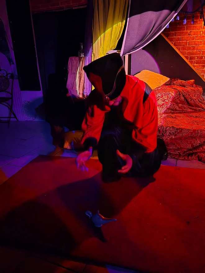 The Vizier kneels on the red carpet in a wash of purple light in Twisted