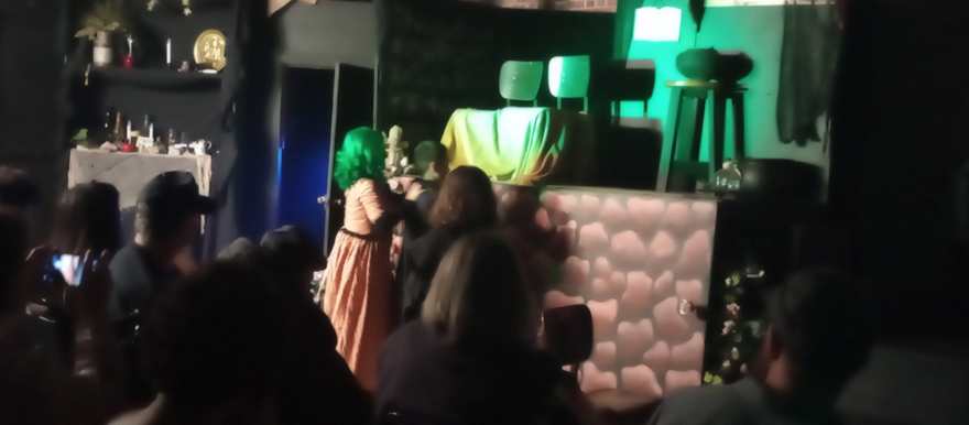 The creature crosses the stage in eerie green light