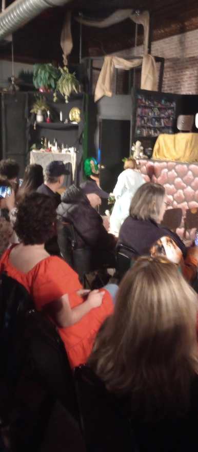 The audience watches from their seats as a scene plays at the stone platform