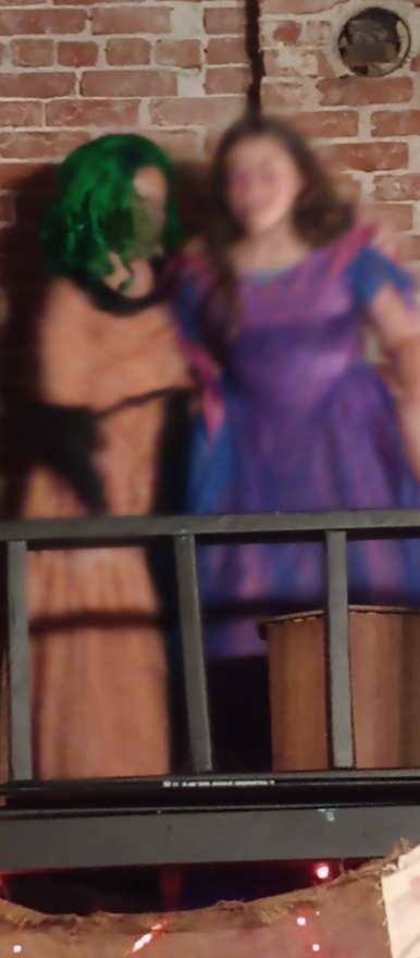 A close view of the creature and the performer in purple on the balcony