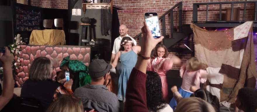 Cast members take their bows as audience phones rise to capture the moment