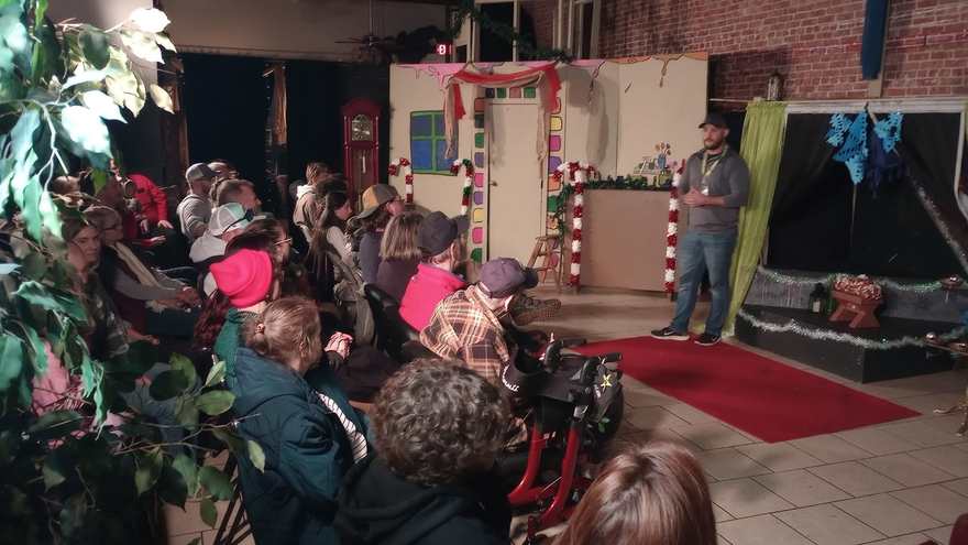 The audience watches from their seats as a host welcomes them from the red carpet before the holiday set