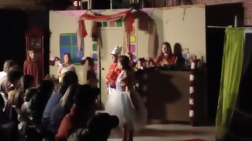 The Nutcracker and Clara in her white tutu play their scene before the candy counter