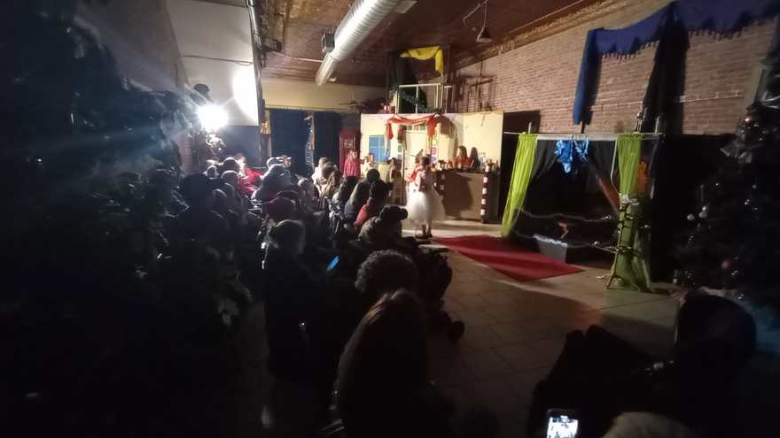 A spotlight flares over the darkened house as the performance continues at the far end of the studio
