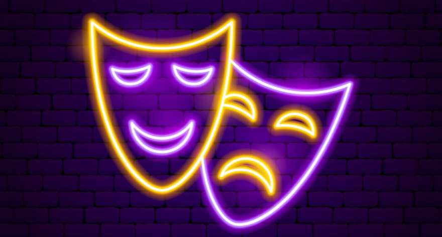 Neon-style comedy and tragedy theatre masks glowing yellow and purple against a dark brick wall
